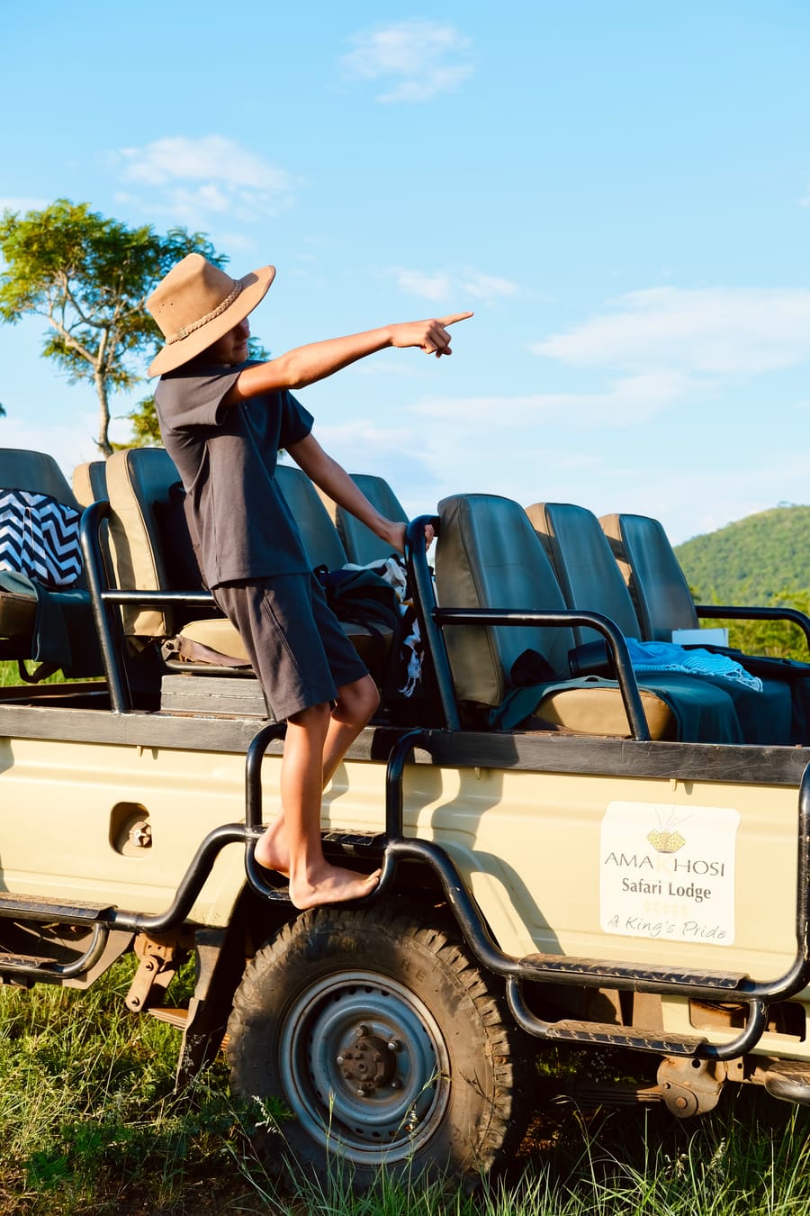 A boy pointing out wildlife from a safari vehicle at Amakhosi Safari Lodge